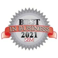 An award badge labeled "best in business 2021 sbm" featuring a silver starburst with a central gray seal, overlaid by a red ribbon.