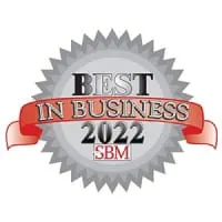 A metallic badge with the words "best in business 2022 sbm" in bold red letters across a silver ribbon, centered over a gray starburst seal design.