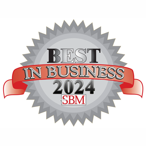 Silver and gray circular badge with a red ribbon across, featuring the text "Best in Business 2024" alongside the initials "SBM".