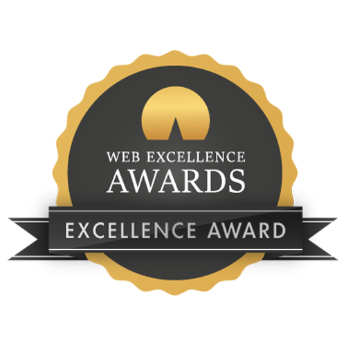 A gray and gold round badge with a scalloped edge labeled "Web Excellence Awards." Below the text, a black ribbon reads "Excellence Award." The badge has a stylized gold mountain peak at the top against a gray circular background.