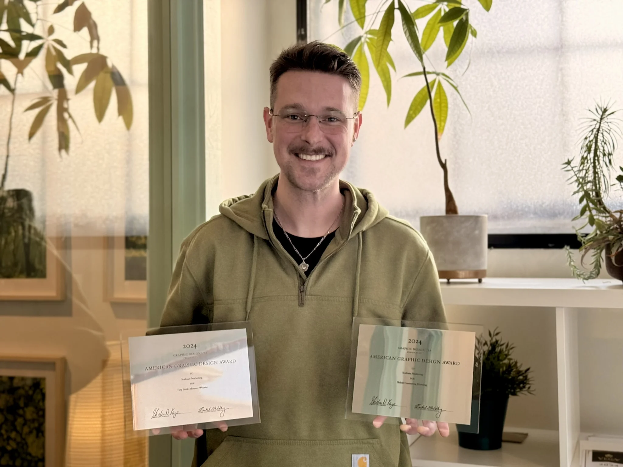 a man holding two certificates