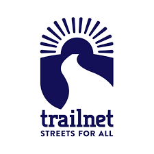 Trailnet logo showing a stylized sun rising over a winding road, with the text "trailnet" and "STREETS FOR ALL" beneath the image.