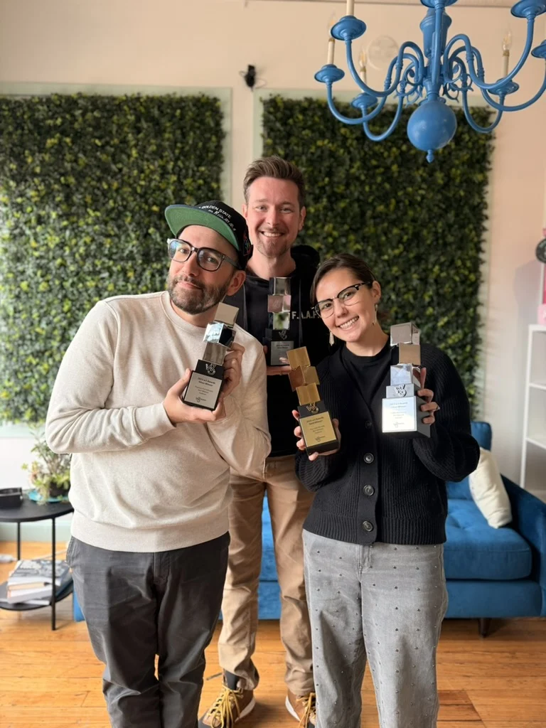 Seafoam team members holding awards in the office